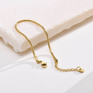 Detail of gold snake chain bracelet with adjustable lobster clasp and polished finish
