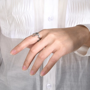 Close-up of a silver lava drip open ring worn on a finger for a minimalist fashion look
