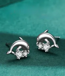 Vue macro de boucles d'oreilles dauphin en argent avec zircons blancs scintillants