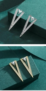 Detailed view of silver and gold V-shaped stud earrings with sparkling cubic zirconia