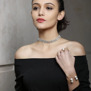 Detailed view of an elegant gold pearl open ring and bracelet set worn by a model
