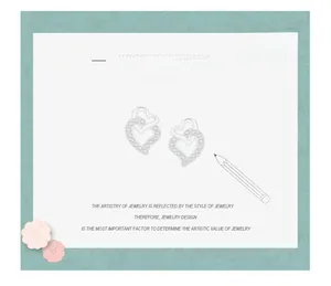 Macro view of interlocking heart earrings sketch with micro-set stones and silver finish