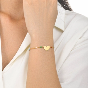 Close-up of golden stainless steel chain bracelet with colorful beads and heart pendant