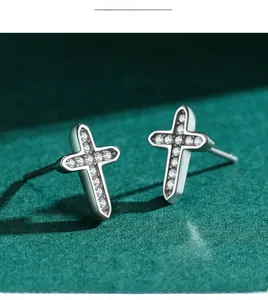Gros plan de boucles d'oreilles croix en argent 925 avec zircons cubiques scintillants