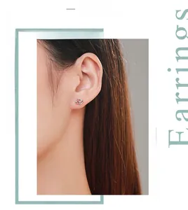 Close-up of S925 sterling silver heart stud earrings with cubic zirconia on model