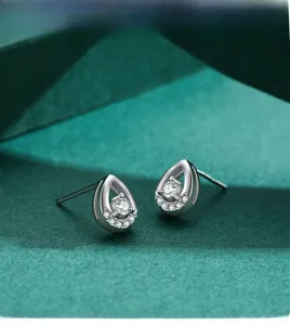 Macro view of teardrop diamond earrings in 925 sterling silver with a round center stone
