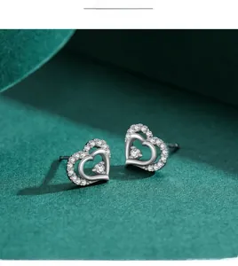 Detailed macro view of heart-shaped silver earrings with sparkling zircon inlay