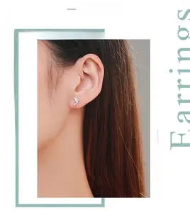 Close-up of s925 sterling silver dolphin stud earrings featuring white cubic zirconia on model