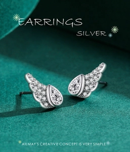 Macro shot of silver angel wing earrings with cubic zirconia and pear-cut center stones