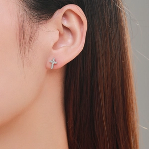 Boucles d'oreilles croix en argent 925 avec zircons portées sur l'oreille femme