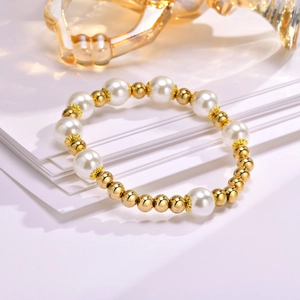 Detailed shot of gold beads and white pearls on an elegant beaded bracelet