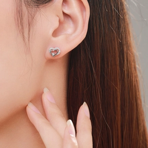 S925 sterling silver hollow heart stud earrings with sparkling cubic zirconia on model