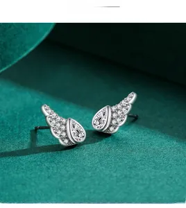 Macro shot of silver angel wing earrings with pear-cut zircon and pavé setting details
