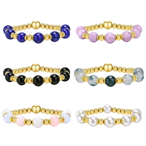 Set of six gold beaded bracelets with natural stones and pearls on white background