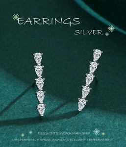 Détail macro de boucles d'oreilles goutte d'eau en argent S925 sur velours vert