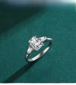 Macro shot of S925 sterling silver emerald cut simulated diamond ring on green texture