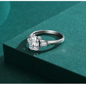 Macro shot of S925 silver ring featuring emerald cut center stone on green pedestal