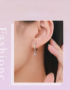Close-up of S925 silver hoop earrings with a rhombic faux diamond drop on a model