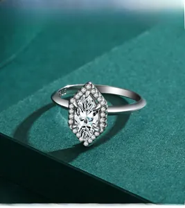 Détail macro d'une bague marquise en argent S925 sur un fond vert luxueux et élégant