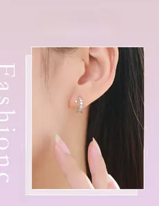 Close-up of 925 sterling silver crisscross stud earrings with sparkling crystals