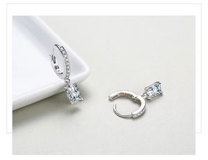 Close-up of S925 sterling silver earrings with rectangular cut zircon on a white plate