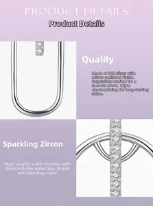 Detailed macro view of S925 silver U-shape earrings with cubic zirconia and mirror polish