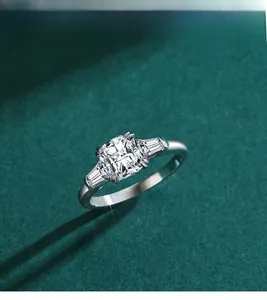 Detail of cushion-cut solitaire ring with side stones on a dark green background
