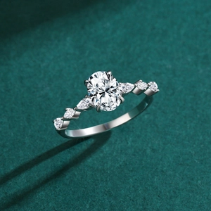 Elegant S925 sterling silver oval cut simulated diamond ring with side stones on green surface