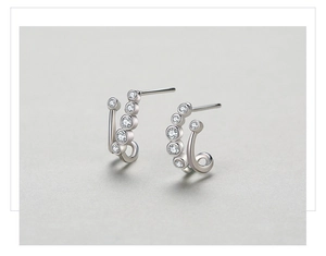 Macro detail of S925 silver C-shape earrings with bubble-set sparkling zircon stones