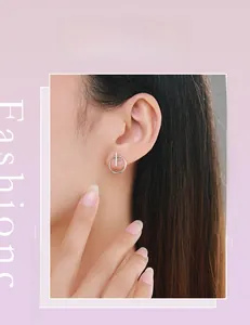 Close-up of minimalist S925 sterling silver circular stud earrings worn on model's ear