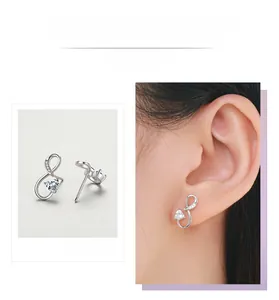 Détails macro et vue portée de boucles d'oreilles cœur infini en argent et zircone