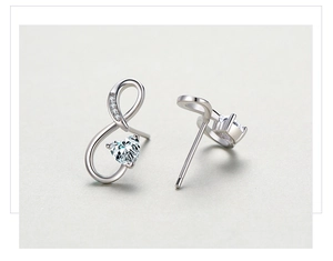 Détail macro de boucles d'oreilles cœur infini en argent 925 avec zircons cubiques