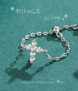 Macro shot of silver cross ring with pavé-set zircons and adjustable chain link