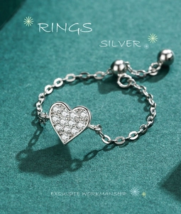 Macro detail of silver adjustable chain ring featuring a pavé heart charm and slider bead