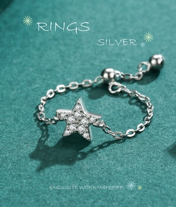 Macro detail of s925 silver chain ring featuring a zircon-studded star charm and beads