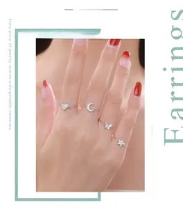Close-up of S925 silver chain rings with heart, moon, butterfly, and star pendants