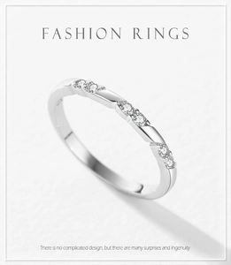 Détail d'une bague en argent 925 torsadée avec six zircons clairs sur fond blanc