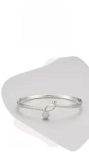 Detail showing polished silver bangle with musical note knot and sparkling pavé ball