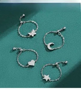 Macro detail of adjustable s925 silver chain rings with star and heart zircon pendants