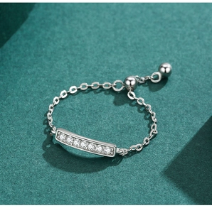 Macro shot of S925 silver chain ring with pavé-set zircons on a green surface
