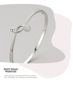 Close-up detail of S925 sterling silver bangle with pave-set diamonds and spherical charm