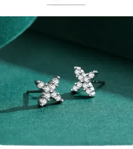 Macro shot of silver X-shaped cross stud earrings with micro-paved cubic zirconia
