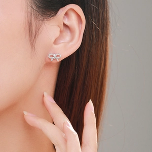 Elegant S925 silver bow stud earrings with micro-set zircons shown on a model