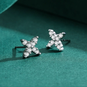 Minimalist S925 silver X-shaped earrings with micro-pave crystals on dark textured surface