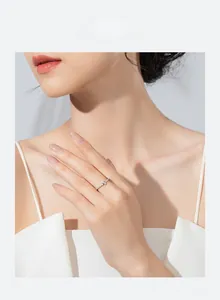 On-finger view of a delicate marquise cut silver ring with pavé diamond band