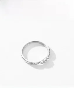 Macro shot of s925 silver ring with three micro-paved round zircons on a white surface