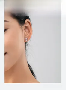 Close-up of minimalist s925 silver heart stud earrings with cubic zirconia on model