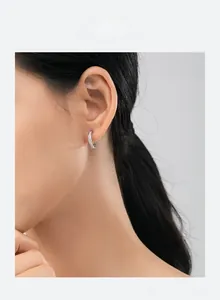 Dettaglio di orecchini a cerchio in argento S925 con zircone rettangolare su modella