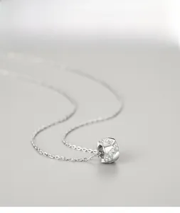 Macro shot of silver S925 geometric pendant with sparkling cubic zirconia on fine cross chain