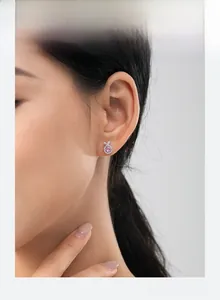 Gros plan d'un clou d'oreille en argent s925 avec zircon rose sur l'oreille d'un mannequin
